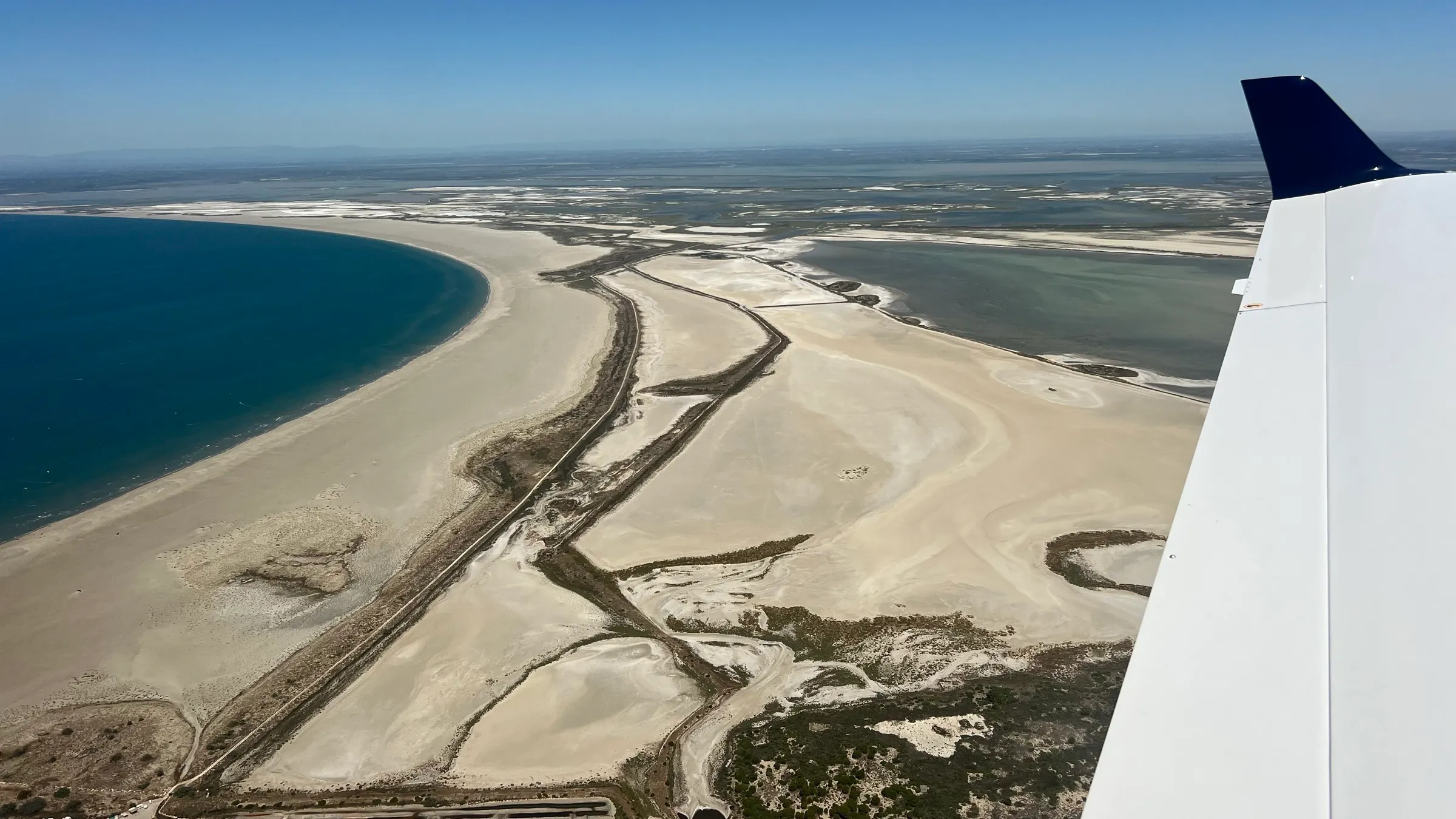 Diamond DA40 wingtip over Spanish coastal salt flats and lagoons